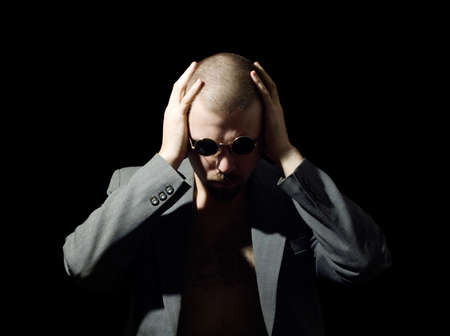 portrait of bristly man in coat in the dark