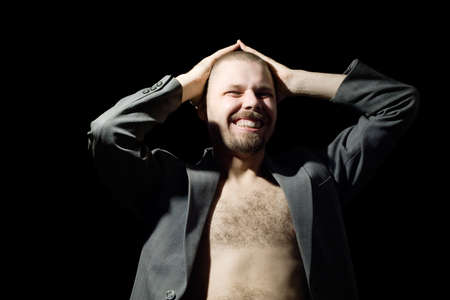 portrait of bristly man in coat in the dark