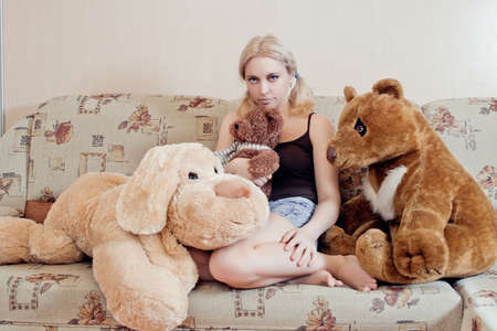 Woman sitting on couch with her plush toysの写真素材