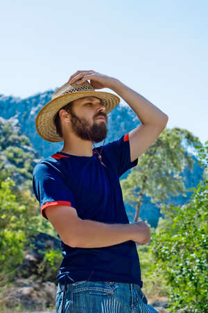 bearded traveler in a hat on a background of mountainsの写真素材