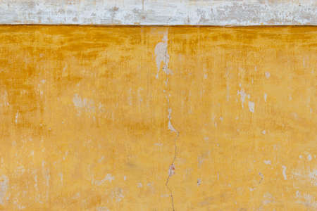 Close-up of yellow cracked stucco wallの写真素材