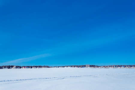 Clear blue sky over a wide snow-covered fieldの写真素材