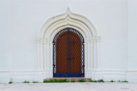 Ancient locked door in a white stone wallの写真素材