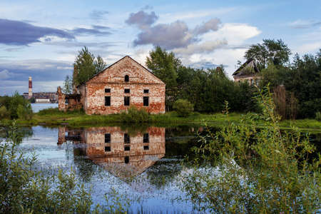 Old house with reflection in the river at duskの写真素材
