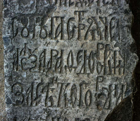 Close-up of ancient gray stone carved of Slavic Writingの写真素材