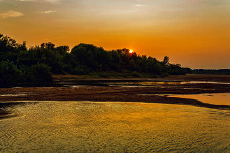 Sun at sunset over the river Vyatkaの写真素材