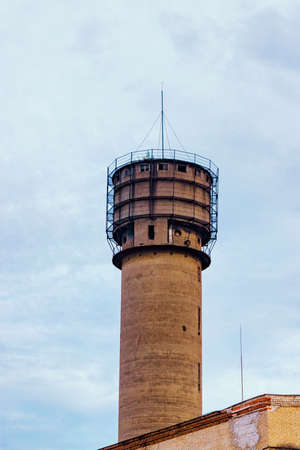 Old brick tower in a factory on a cloudy dayの写真素材