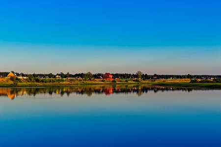russian village on the lake in the summer eveningの写真素材