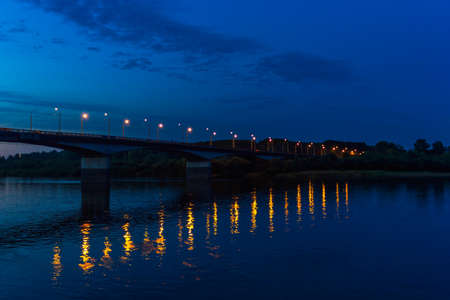 Road bridge over the Vyatka river with reflection of lanterns in the water at nightの写真素材