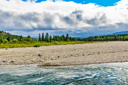 A clear rapid northern river flowing among the rocks on a summer dayの写真素材