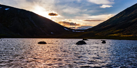 Sunset on the mountain lake in the Subpolar Urals on a summer evening