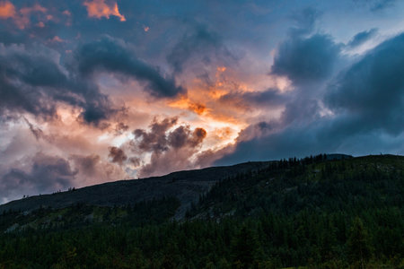 Clouds at sunset over the mountains of the Subpolar Urals on a summer evening