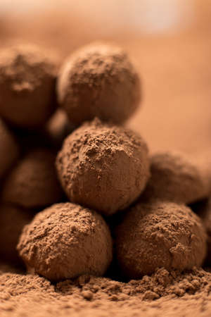 Homemade cooking. Stack of appetizing black chocolate round truffles covered in cocoa dust. Shallow depth of field, close upの写真素材
