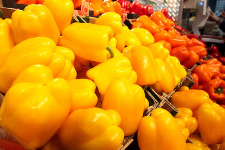 Crates with orange and red peppers at marketの写真素材