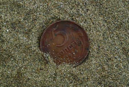 metal coin in the sandの写真素材