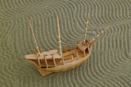 model ship on the waves drawn on the sandの写真素材