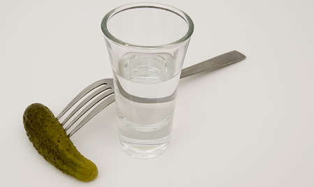 Close-up of glass with vodka and fork with cucumber.の写真素材