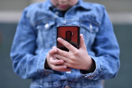 Closeup of Teenager holding a phone in his handの写真素材
