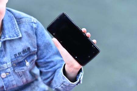 Closeup of Teenager holding a phone in his handの写真素材