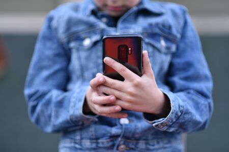 Closeup of Teenager holding a phone in his handの写真素材