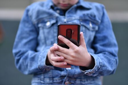 Closeup of Teenager holding a phone in his handの写真素材