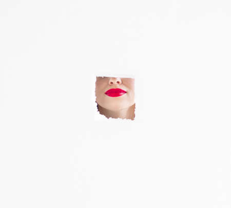 Close-up view of female wearing red lipstick with mouth open over white background.の写真素材