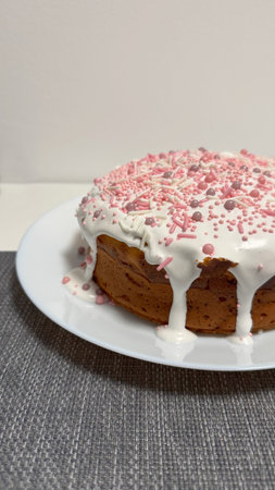 Deliciously decorated cake topped with white icing and colorful sprinkles on a plate