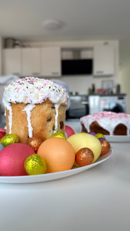 Colorful Easter cake surrounded by vibrant eggs on a white plate in a modern kitchen setting