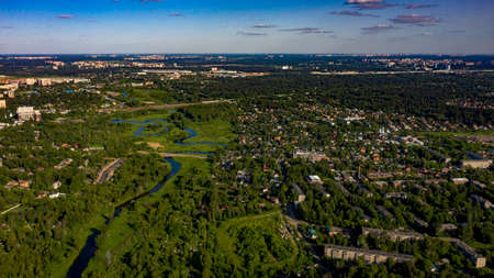 aerial photo of the town in the forest near the river with cumulus clouds