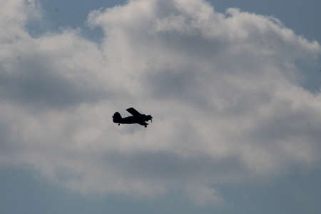Silhouette of an airplane in the sky over the field. Sky over the field
