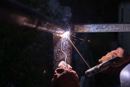 Industrial Worker at the factory welding closeup. Welder working welding steelの写真素材