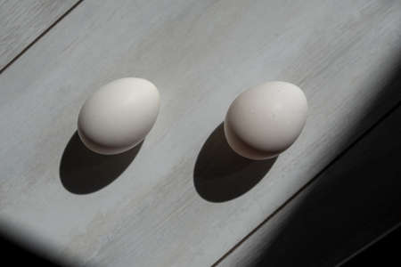 two white eggs on wood background. protein