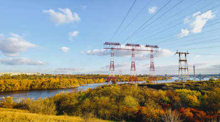 high voltage pillar, overhead power line, industrial background. power lines on the river
