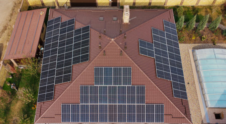 Row of blue solar panels on orange roof. Group of blue solar collectors with orange roof tiles....