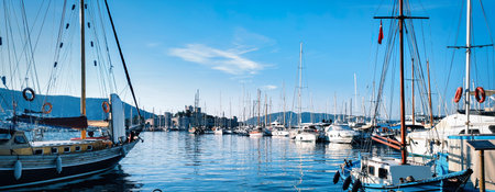 Picture of row of sailboats reflected in water, yacht port on the bay, water transport, ocean transportation, beautiful vessel in the harbor, summer vacation, active lifestyle, holiday conceptの写真素材