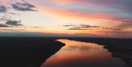 sunset with clouds, light rays over river with reflectionsの写真素材