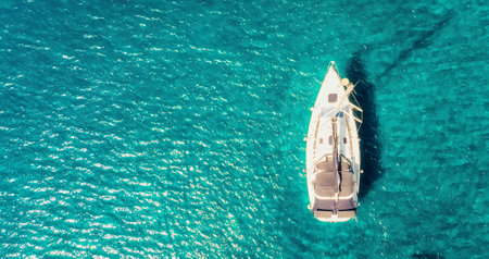 Boat sail floats near the shore. Luxury Lifestyle. Travel on sailboat at sea with clear water. Calm placeの写真素材
