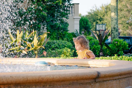 little girl looking into fountainの写真素材