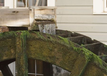 Old pioneer era wood waterwheel attached to building for grinding grain