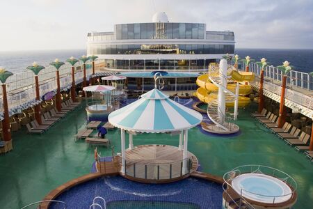 The top deck of a cruise ship with water slides, hot tubs, pool, and other items