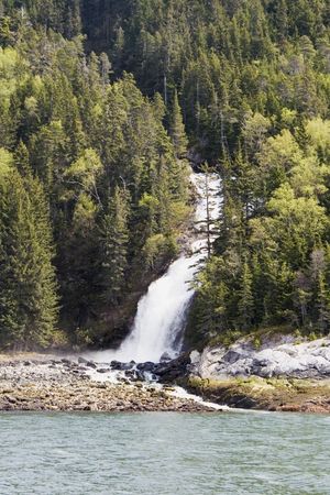 Small waterfall falling into the ocean in some mountains near Skagway; Alaska
