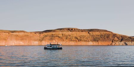 Houseboat at Lake Powell in Glen Canyon National Recreation Area, Utah with beautiful red rocks in backgroundの写真素材