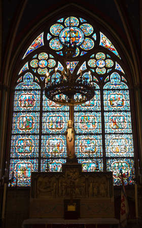 Statue of the Virgin Mary inside a cove in Notre Dame Cathedral with stained glass in the backgroundのeditorial素材