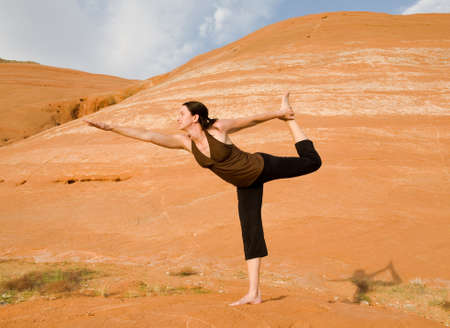 Woman doing yoga in the wilderness against a beautiful wilderness backdrop at Lake Powell, Glen Canyon National Recreation Area, Utahの写真素材