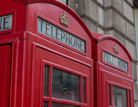 Two red telephone booths side by side in London, England.