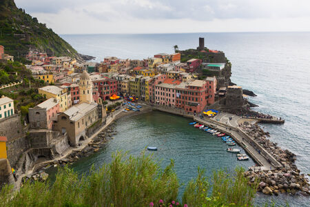 Colorful buildings and harbor of Vernazza in Cinque Terre, Italy shot from above.
