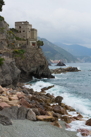 Beach and tower along the Mediterranean ocean in Monterosso in Cinque Terre, Italy.のeditorial素材