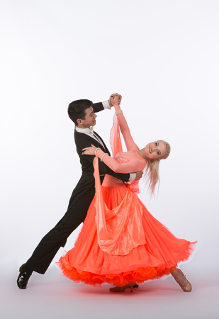 Two young ballroom dancers in studio taken against a high-key white backgroundの写真素材