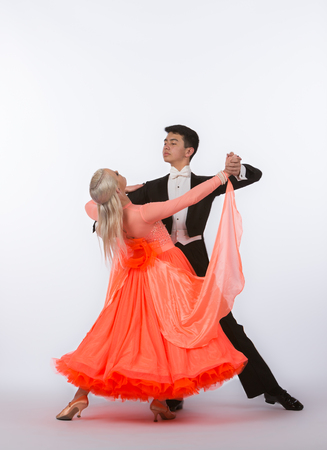 Two young ballroom dancers in studio taken against a high-key white backgroundの写真素材