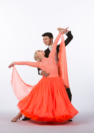 Two young ballroom dancers in studio taken against a high-key white backgroundの写真素材